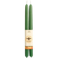 Two green candles with a label on a white background