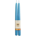 Two blue candles with a label on a white background