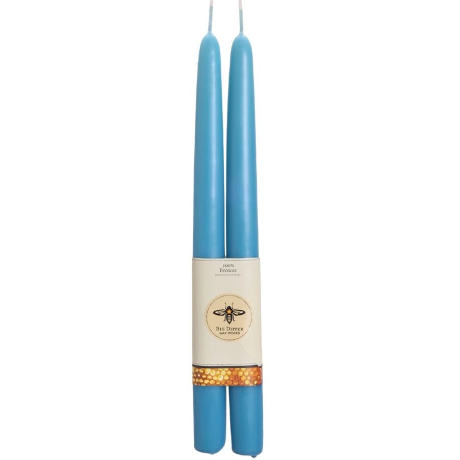 Two blue candles with a label on a white background