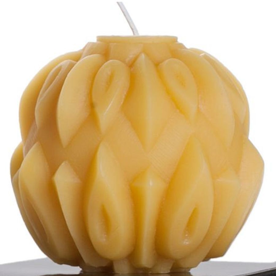 Beeswax candle with intricate braided design on a white background