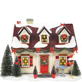 Decorative Christmas house with snow, trees, and festive decorations on a white background