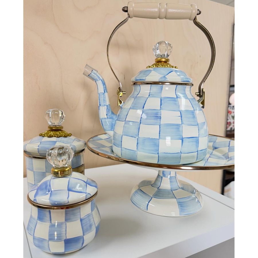 Blue and white checkered teapot and jar set on a stand with a neutral background