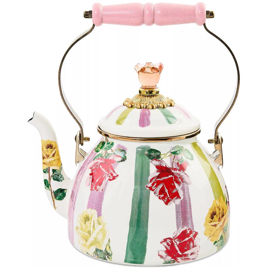 Decorative teapot with floral design and pink handle on a white background