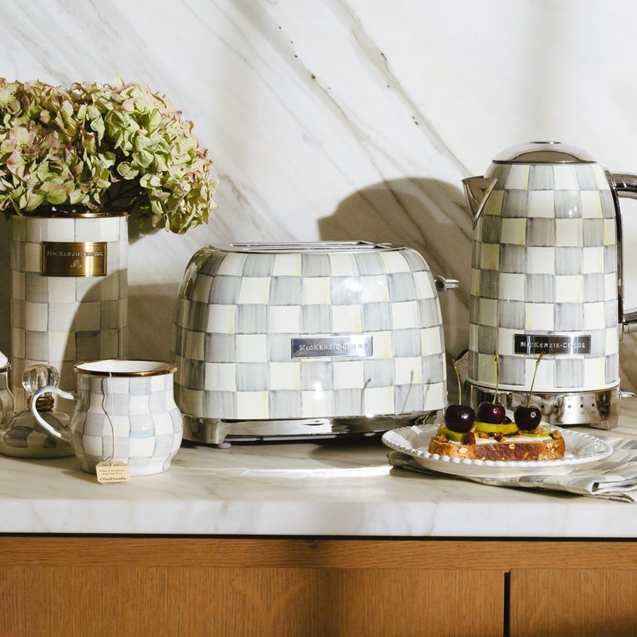 Kitchen counter with mosaic-patterned toaster, kettle, and mug on a light background