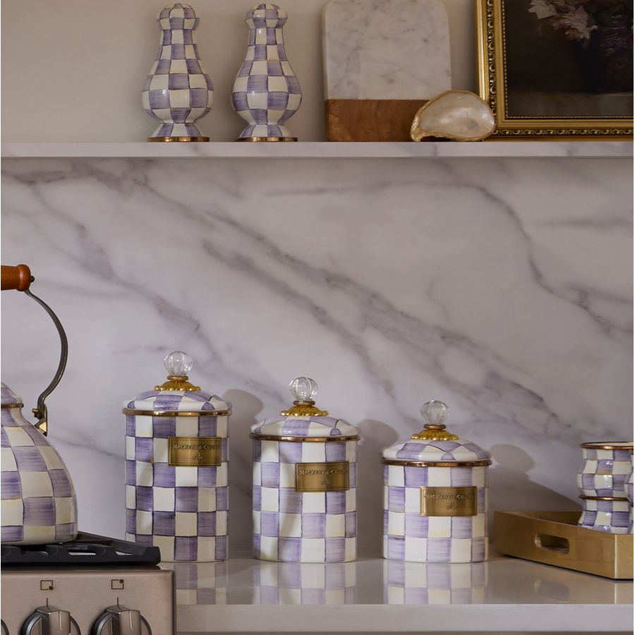 Decorative canisters with checkered pattern on a marble countertop