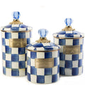 Set of three blue and white checkered canisters with gold accents on a white background