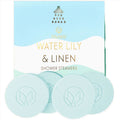 Shower steamers with 'Water Lily & Linen' fragrance packaging on a light blue background