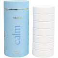 Blue cylindrical container labeled 'musee' with 'calm' text, next to a stack of white bath tablets.