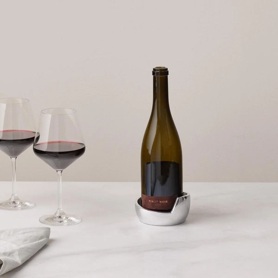 Wine bottle with two glasses of red wine on a white surface