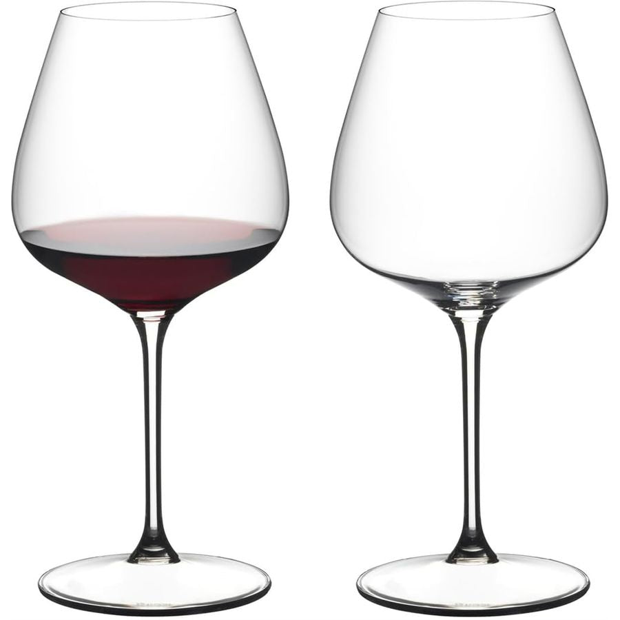Reidel red wine glasses, one filled with red wine, clear glass, stem design.