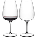 Reidel red wine glasses, one with red wine, clear crystal, stem design.