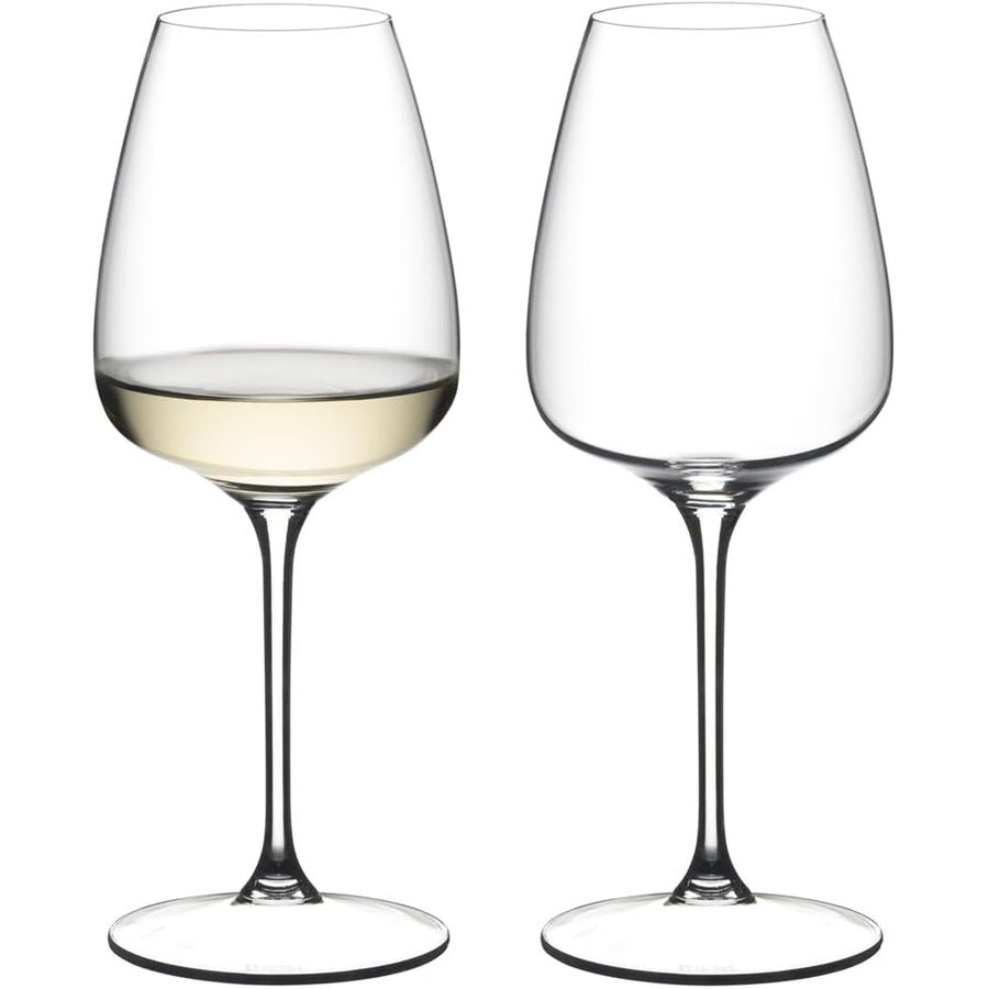 Reidel white wine glasses, one filled with white wine, clear glass with stem and base.
