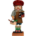Wooden figurine of a man with a red hat and brown apron holding a toy train on a white background