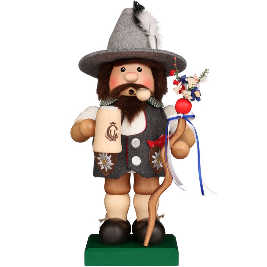Traditional German wooden figurine with a hat and decorative items on a white background