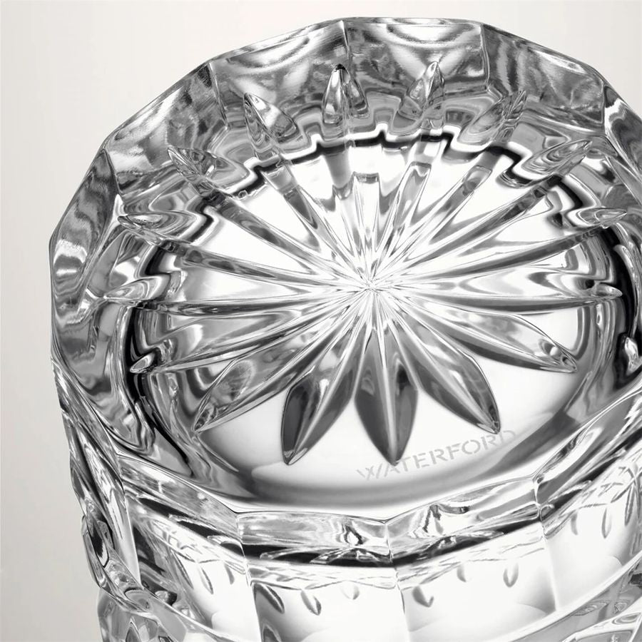 Close-up of a crystal glass with 'Waterford' branding on a light gray background