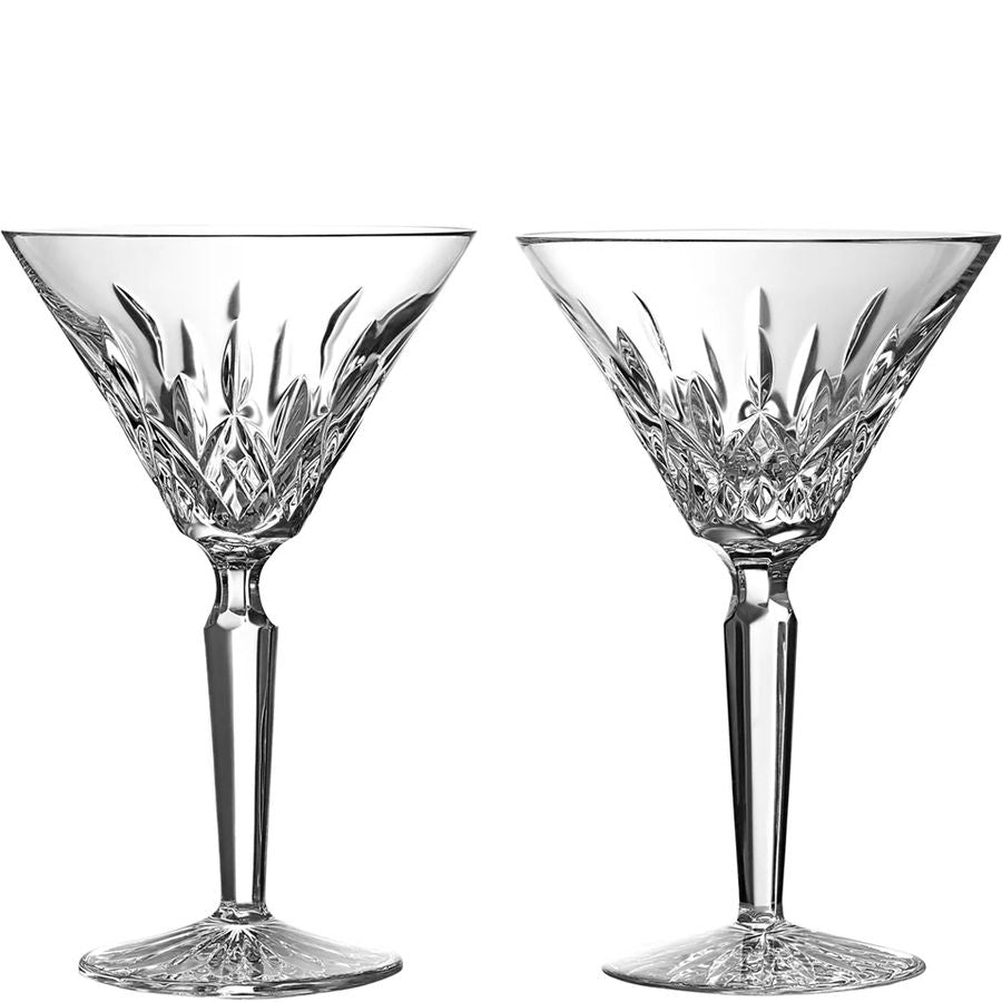 Two crystal cocktail glasses with intricate designs on a white background