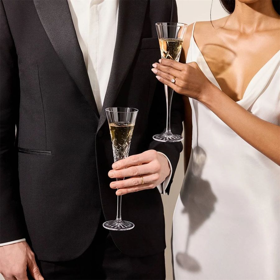Man and woman in formal attire holding champagne glasses.